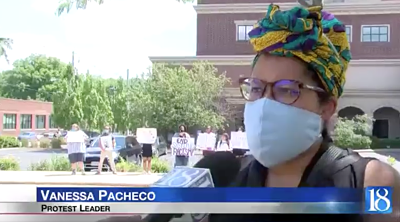 Photo of a Black woman wearing a headscarf being interviewed. Bottom band reads Vanessa Pacheco, Protest Leader